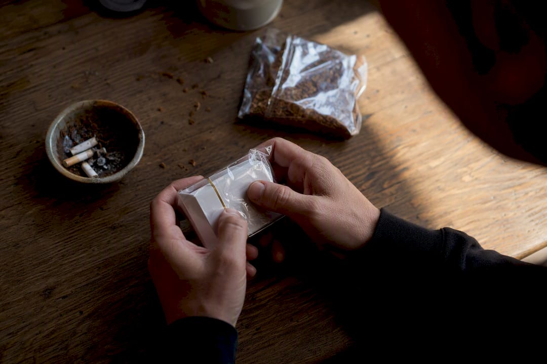 Hands squeezing cigarette pack for freshness